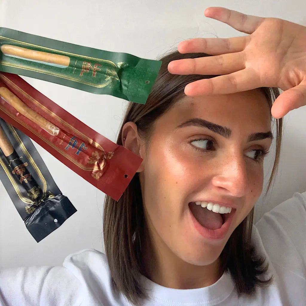 Femme tenant 3 siwak dans les mains
