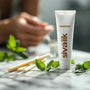 Composition zen de bâtons de siwak et d’un tube de dentifrice au siwak, posés sur un marbre épuré, entourés de feuilles de menthe pour une fraîcheur naturelle.