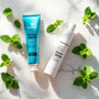 Tube de dentifrice SiwakSmile et bâtons de siwak naturel posés sur marbre blanc, entourés de feuilles de menthe, évoquant la fraîcheur et la pureté du siwak dent.