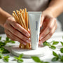 Flacon de dentifrice SiwakSmile et bâtons de siwak disposés sur un marbre blanc entouré de brins de menthe. Ambiance spa évoquant siwak avis dentiste et pureté naturelle.