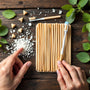 Plan zen révélant un siwak dangereux aux racines boisées authentiques, un tube SiwakSmile et des feuilles de menthe évoquant pureté et fraîcheur naturelle.